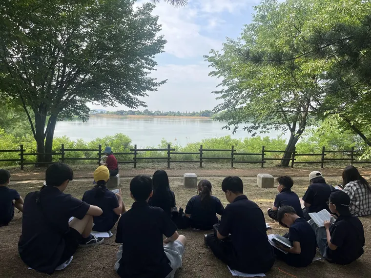 야외에 둘러앉아 이야기를 나누는 학생들