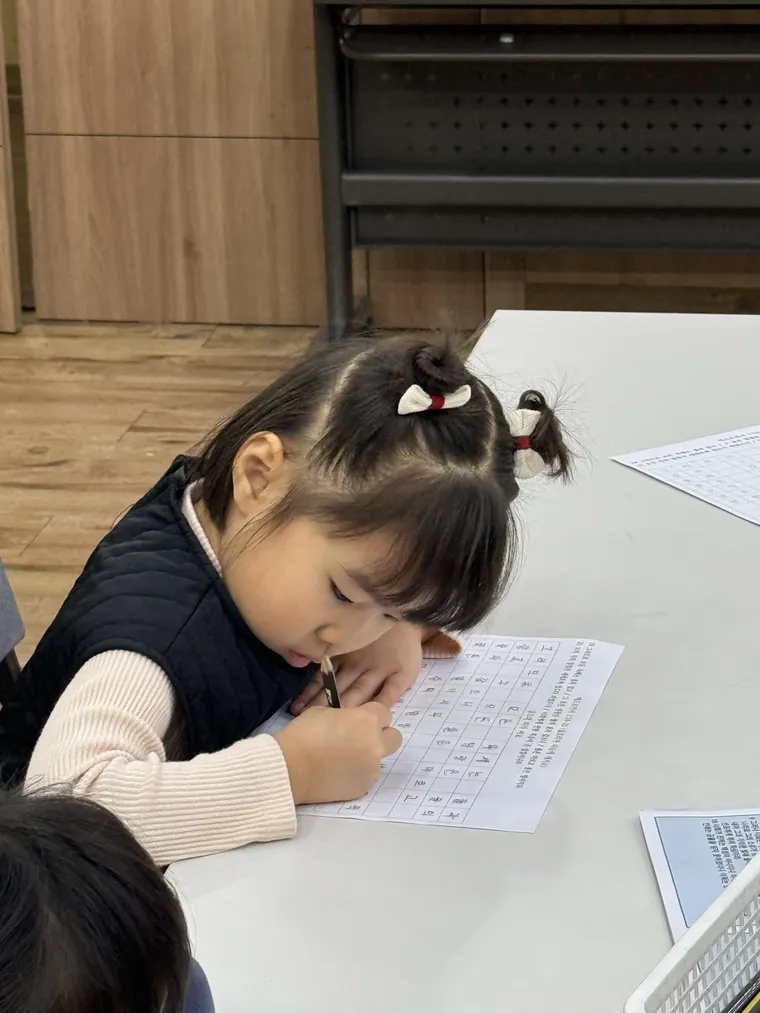 책상에서 글을 쓰는 학생